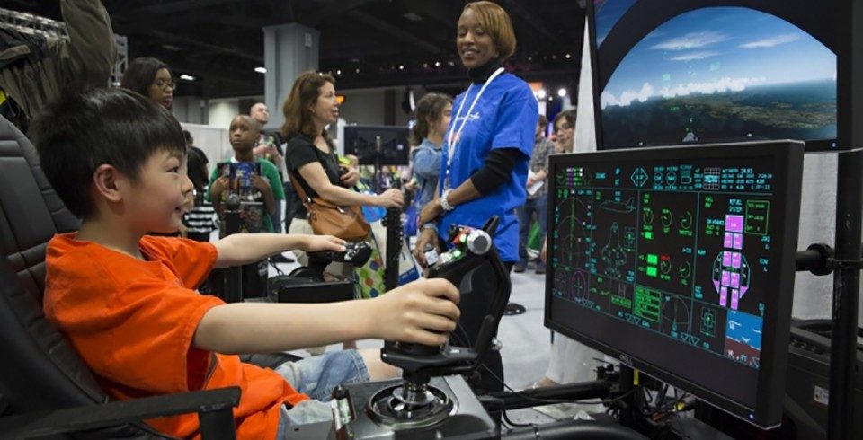 Child operating a flight simulator at a STEM event